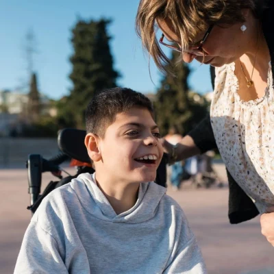 Disabled boy on wheelchair with mother